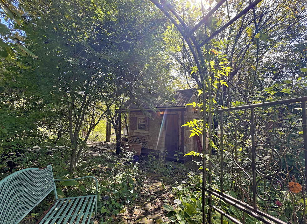 沢山の草木が生い茂る庭に建つ小屋。