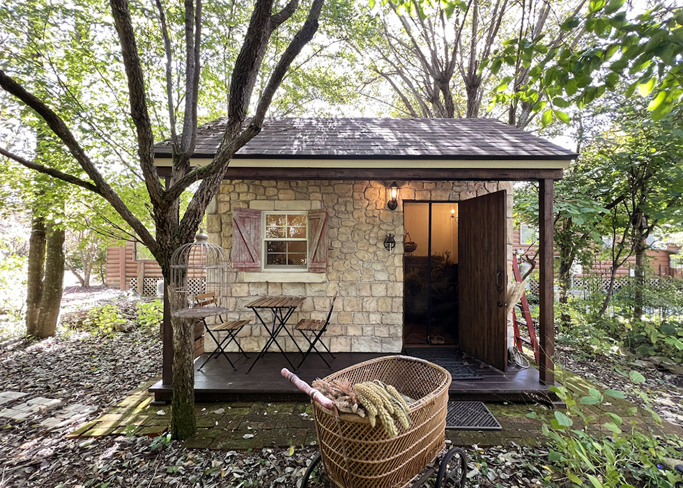 モルタル造形で外壁の4面全てを石積み風に彩った小屋の外観