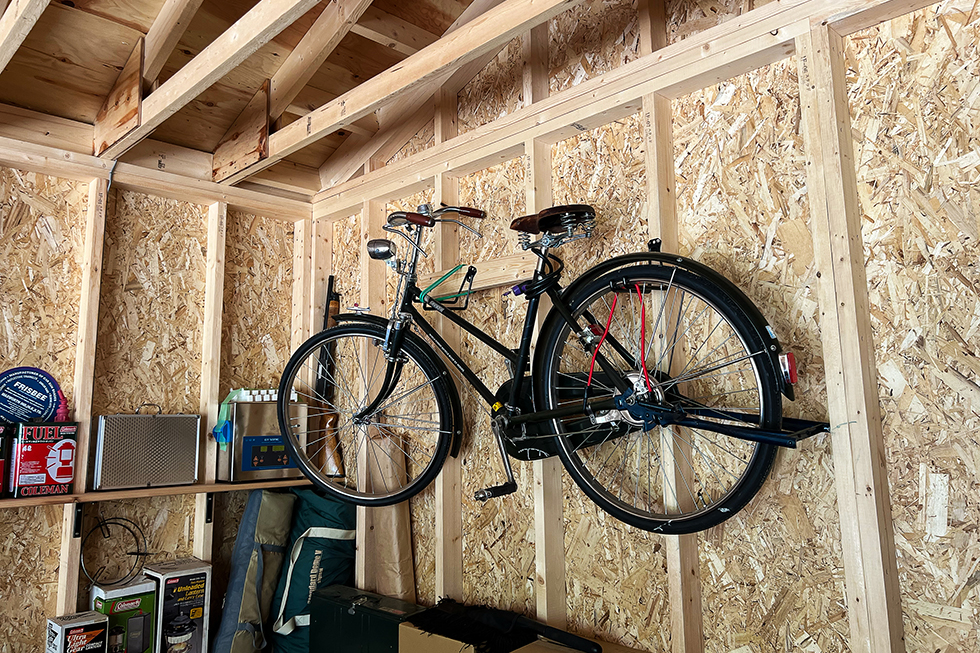 ガレージ内の壁には、オーナーがDIYで取り付けたフックに自転車がかけられています。