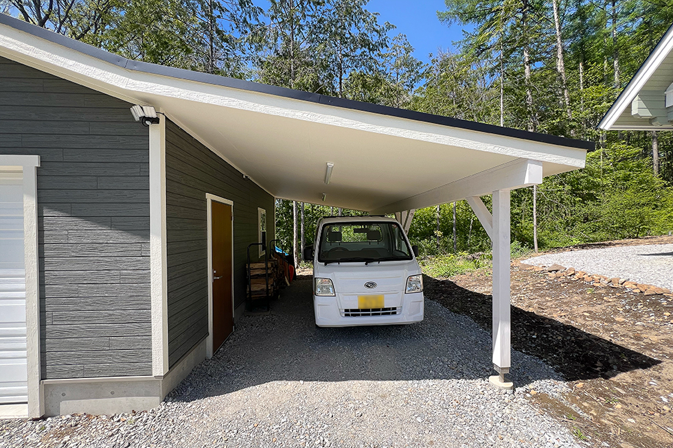 ガレージ横に付いた差掛け屋根には、軽自動車が停められています。